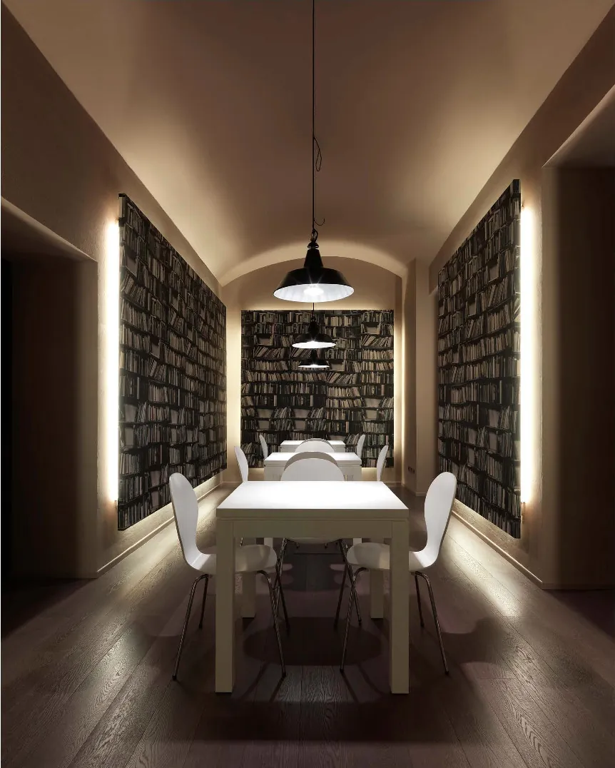 Sala riunioni con pareti libreria e luci lineari
